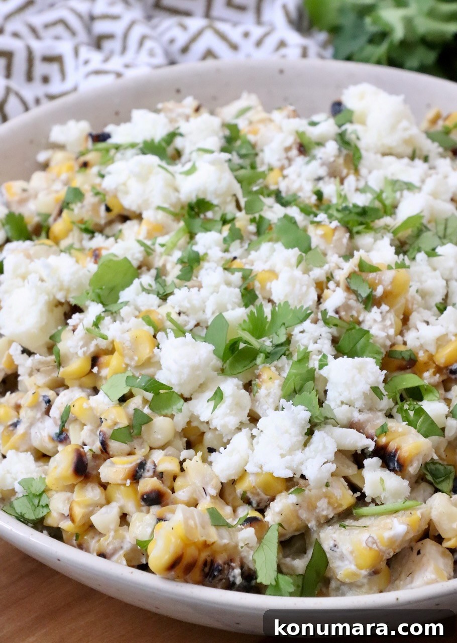 Mexican street corn in a bowl topped with crumbled cheese and cilantro