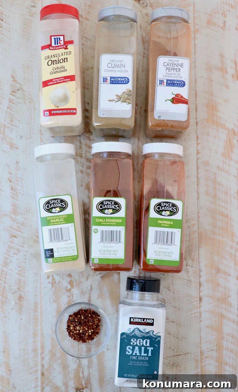 containers of spices lined up on white wood board