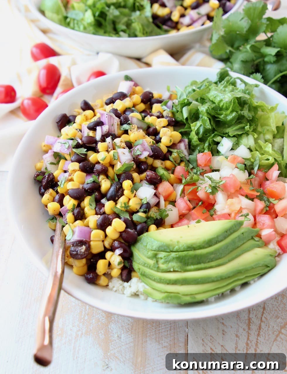 Loaded Vegan Burrito Bowl with Black Beans and Avocado 3 Vegan burrito bowl topped with avocado, black beans, corn, tomatoes and romaine lettuce