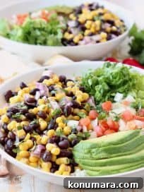 Loaded Vegan Burrito Bowl with Black Beans and Avocado 5 White bowl with sliced avocado, black bean and corn relish, diced tomatoes and shredded lettuce