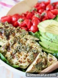 Grilled Chicken and Avocado Pesto Salad 9 Sliced pesto chicken in bowl with sliced avocado and diced cherry tomatoes
