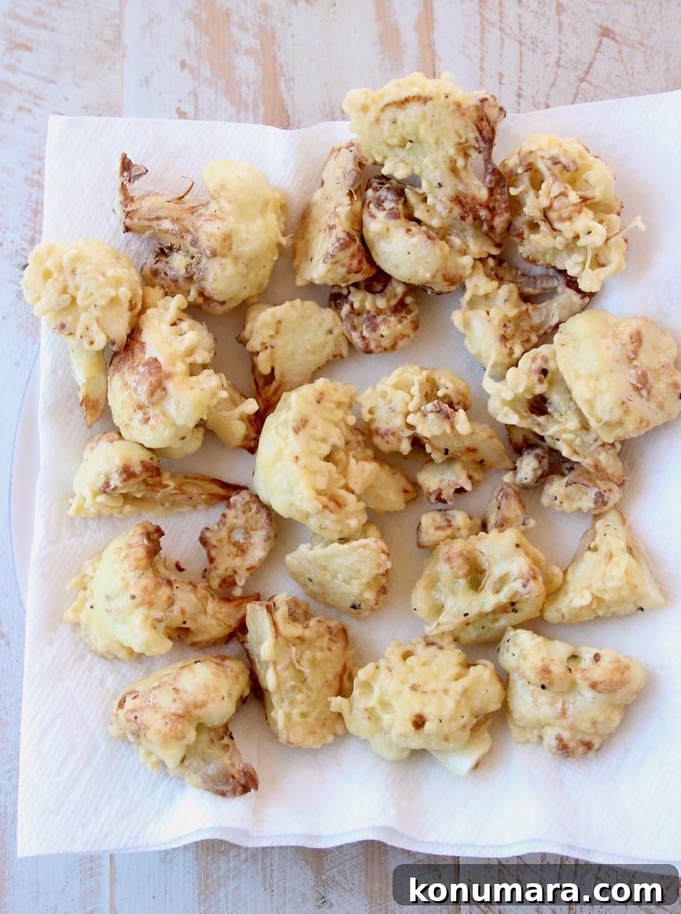 Crispy Korean-Style Fried Cauliflower with Gochujang Glaze 4 Fried cauliflower pieces on paper towel lined plate