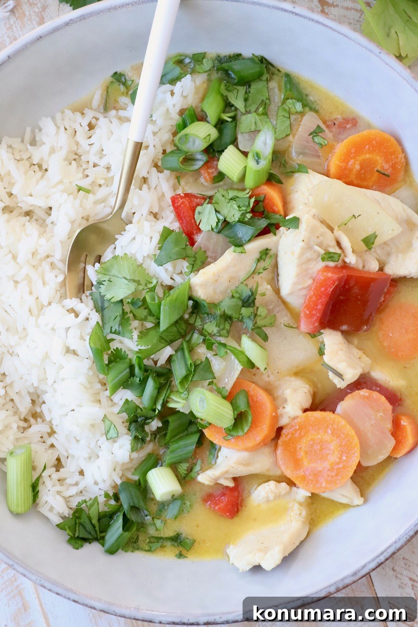 Authentic Thai Yellow Curry Recipe with Coconut Milk 7 vegetables and chicken in yellow curry sauce in bowl with cooked white rice
