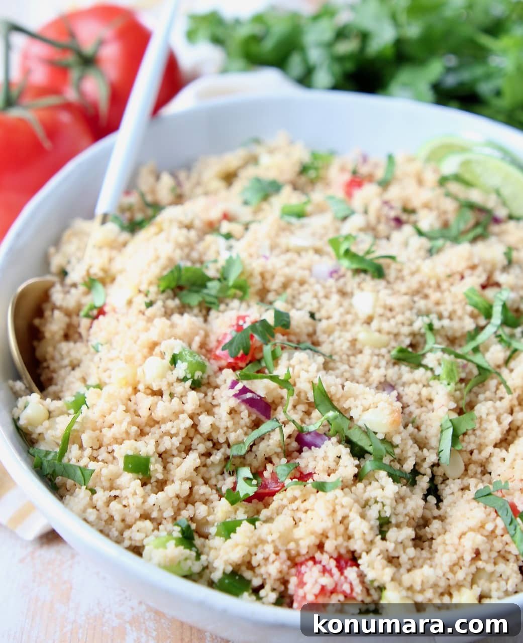 Roasted Tomatillo and Corn Couscous Recipe 2 Bowl filled with couscous, diced tomatoes, cilantro and lime wedges