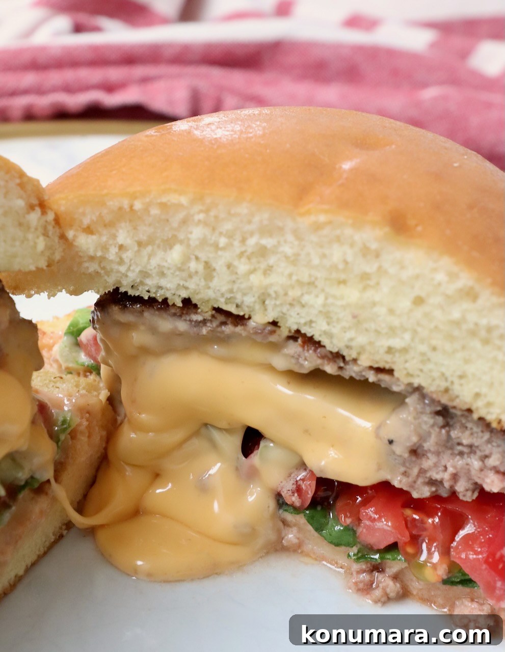 melted cheese coming out of the middle of a burger on a plate