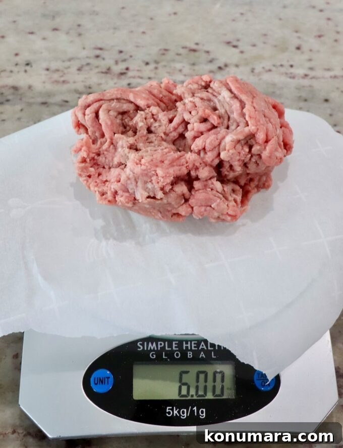 ground beef on a piece of parchment paper on a kitchen scale