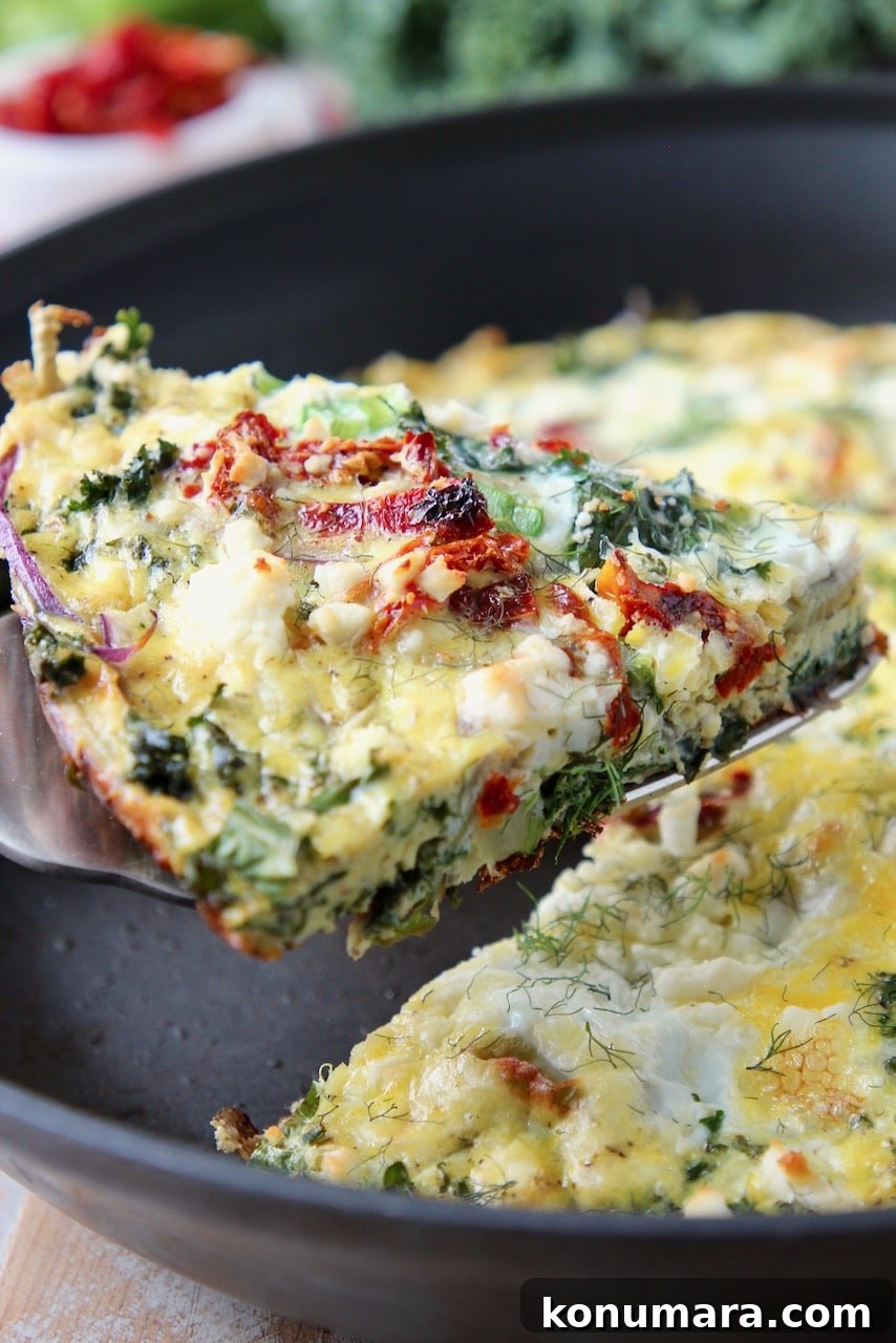 Slice of vegetable frittata lifted out of skillet with a spatula
