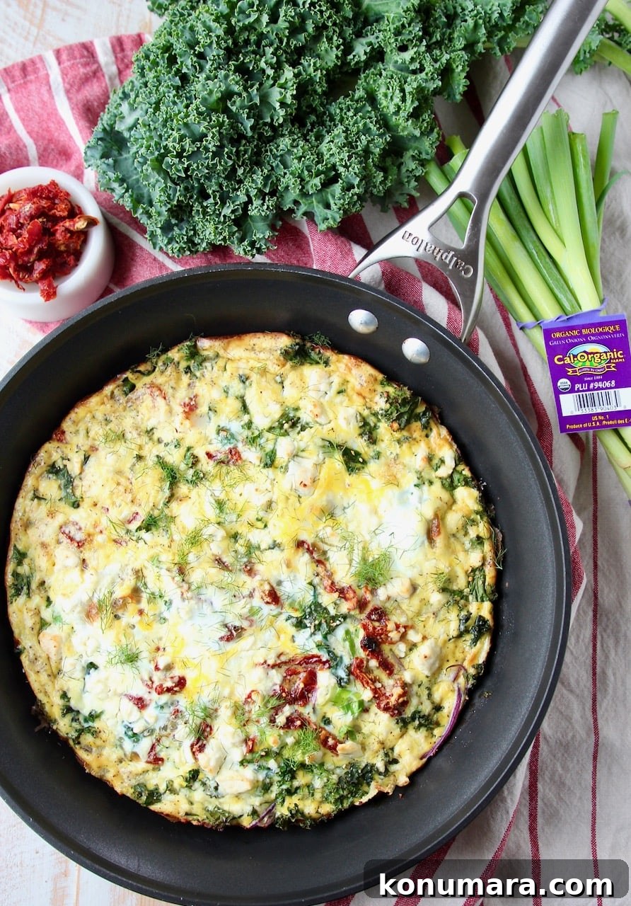 Vegetarian frittata in skillet with fresh kale and green onions on the side