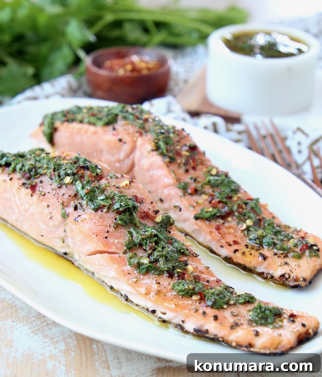 Slices of salmon on plate topped with chimichurri sauce