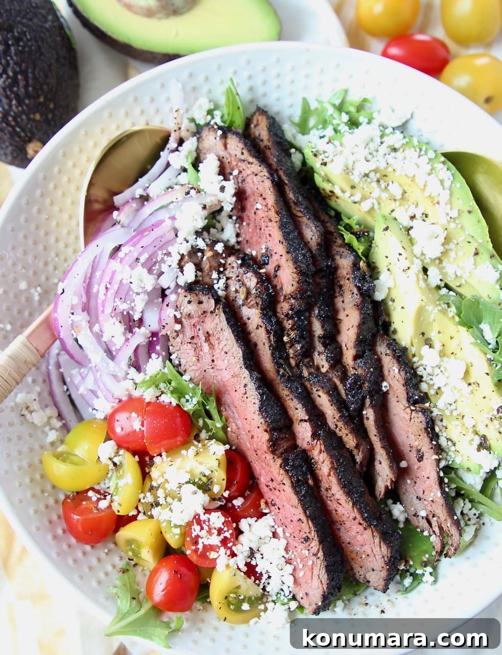 Grilled steak salad in a bowl with avocado, tomatoes and red onions