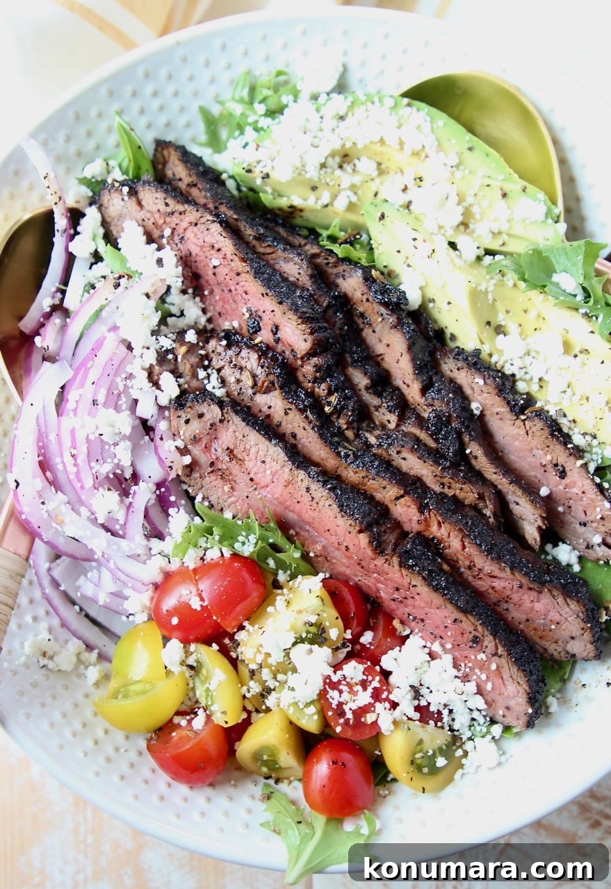 Steak salad in bowl with tomatoes, avocado and onions