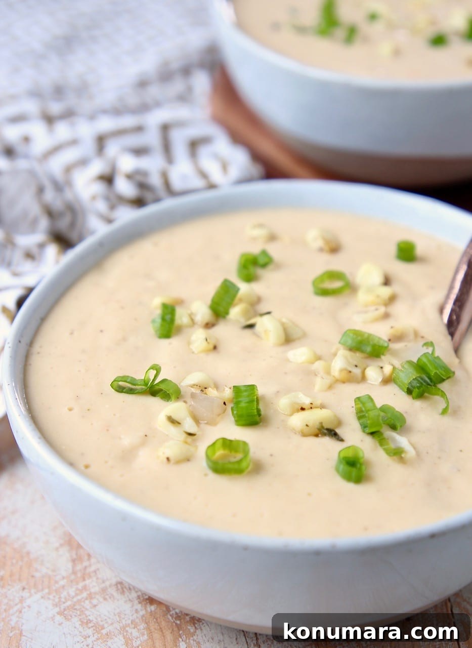Creamy sweet corn chowder in bowl with copper spoon