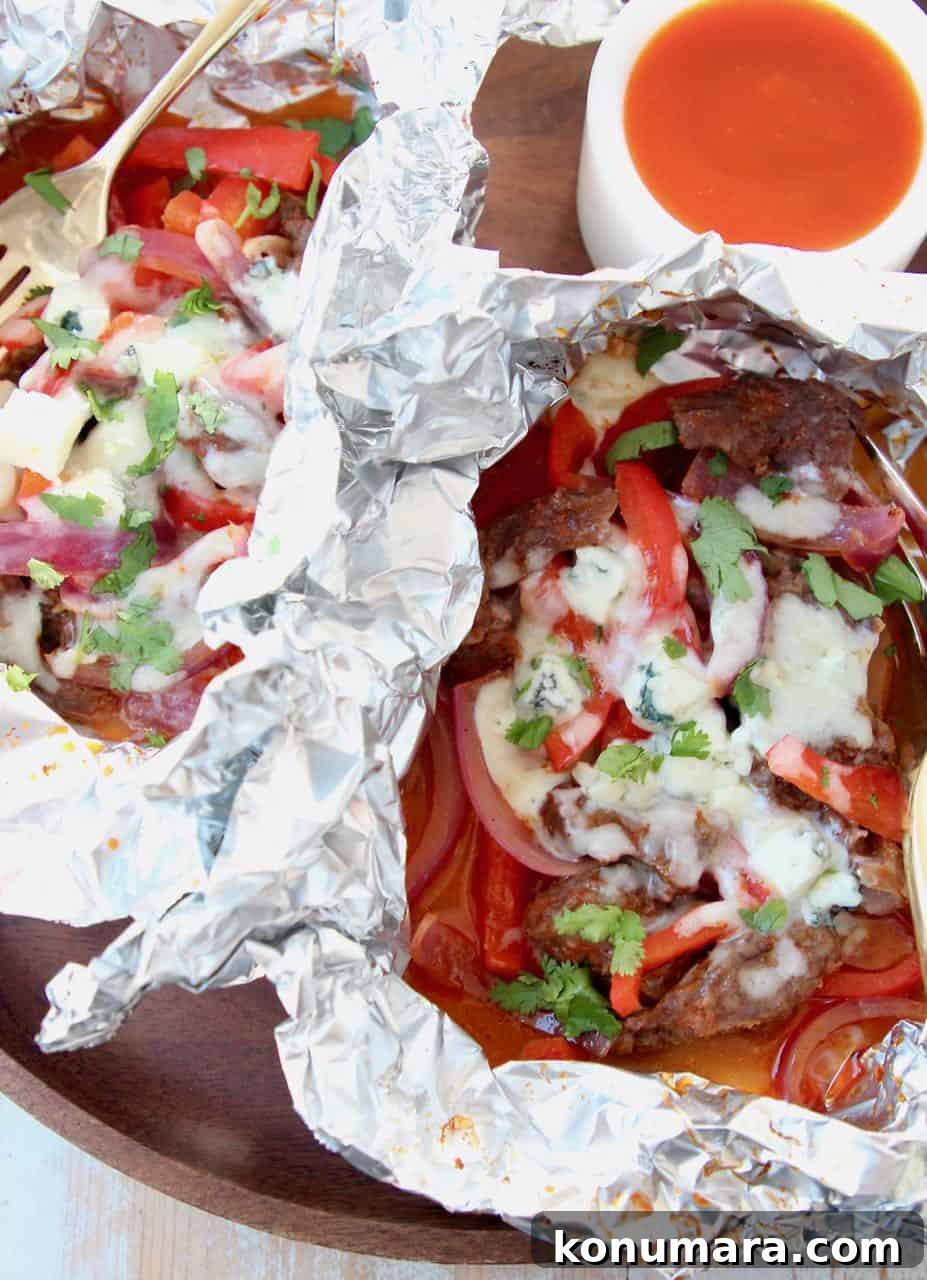 Steak, peppers, onions and melted cheese in foil pack