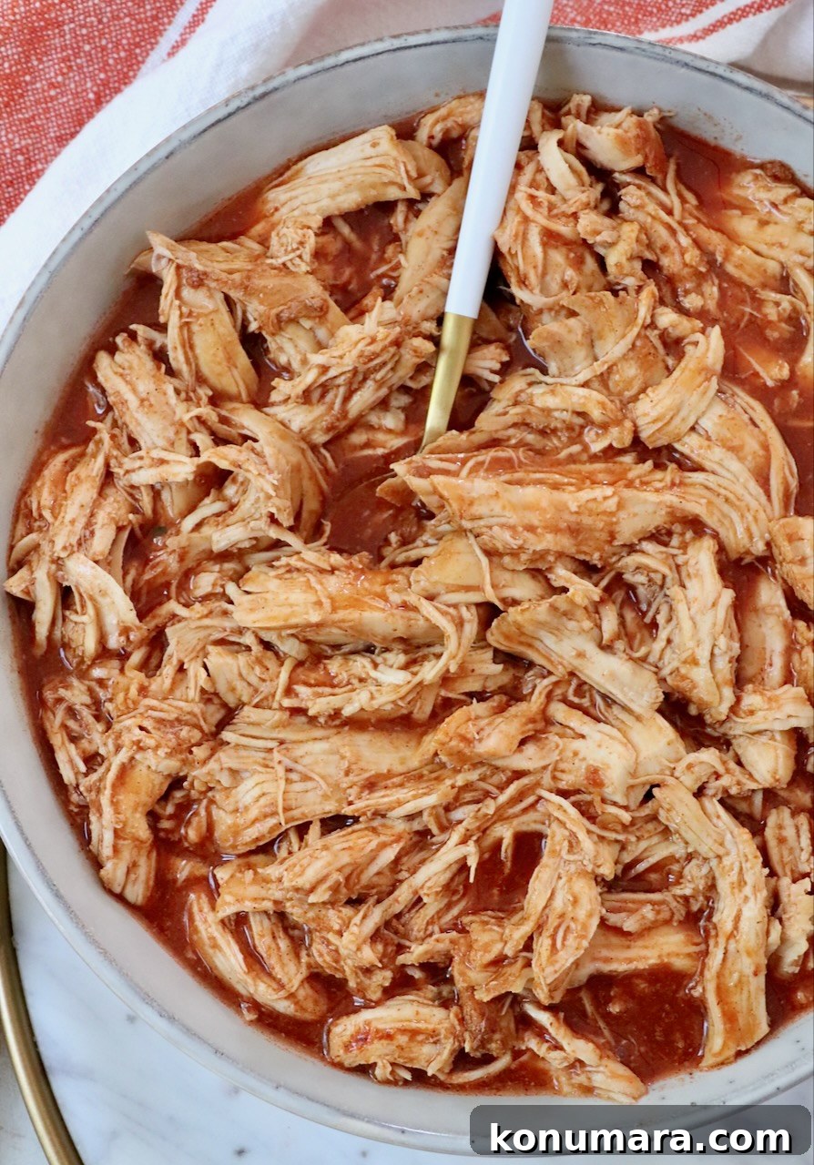 Slow Cooker Buffalo Chicken Recipe 4 shredded chicken with buffalo sauce in bowl with fork