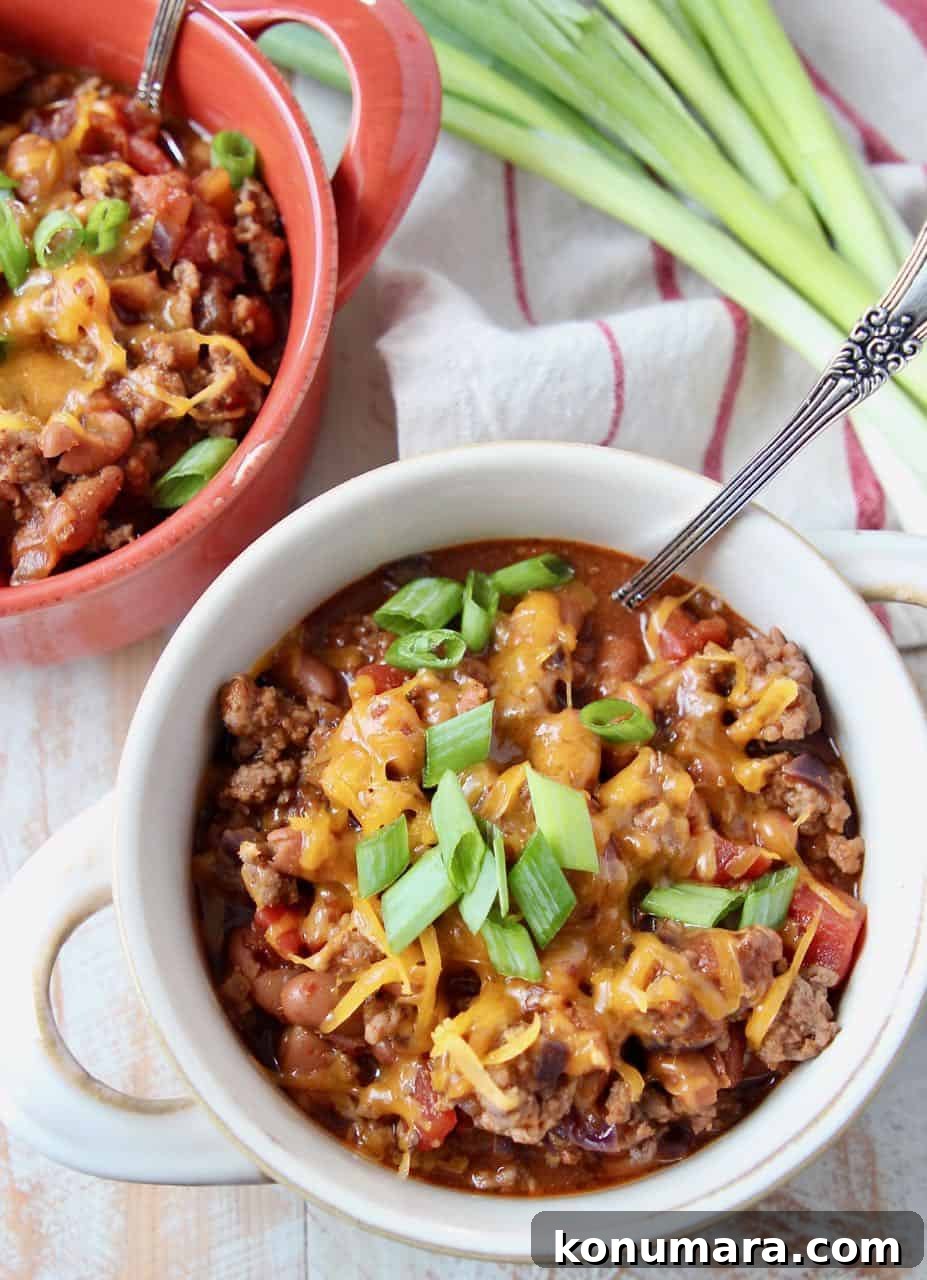 Overhead image of chili in crocks with silver spoon and green onions