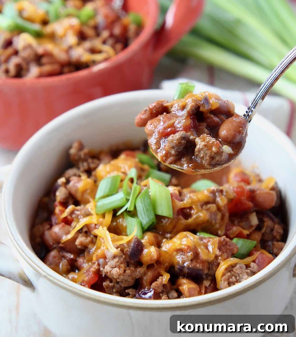 Chili in white bowl with spoonful of chili coming out of the bowl