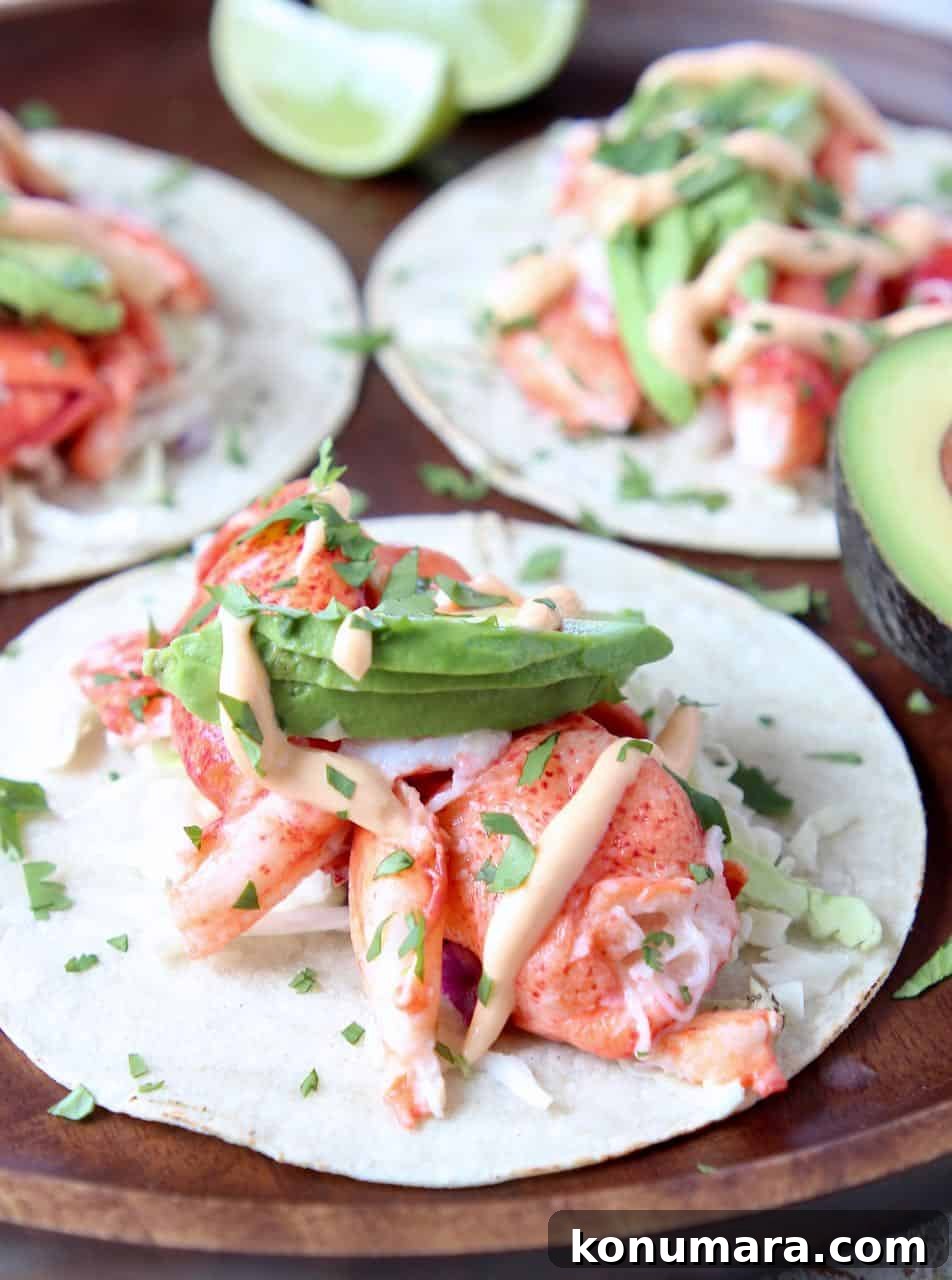 Lobster tacos topped with avocado on wood serving tray