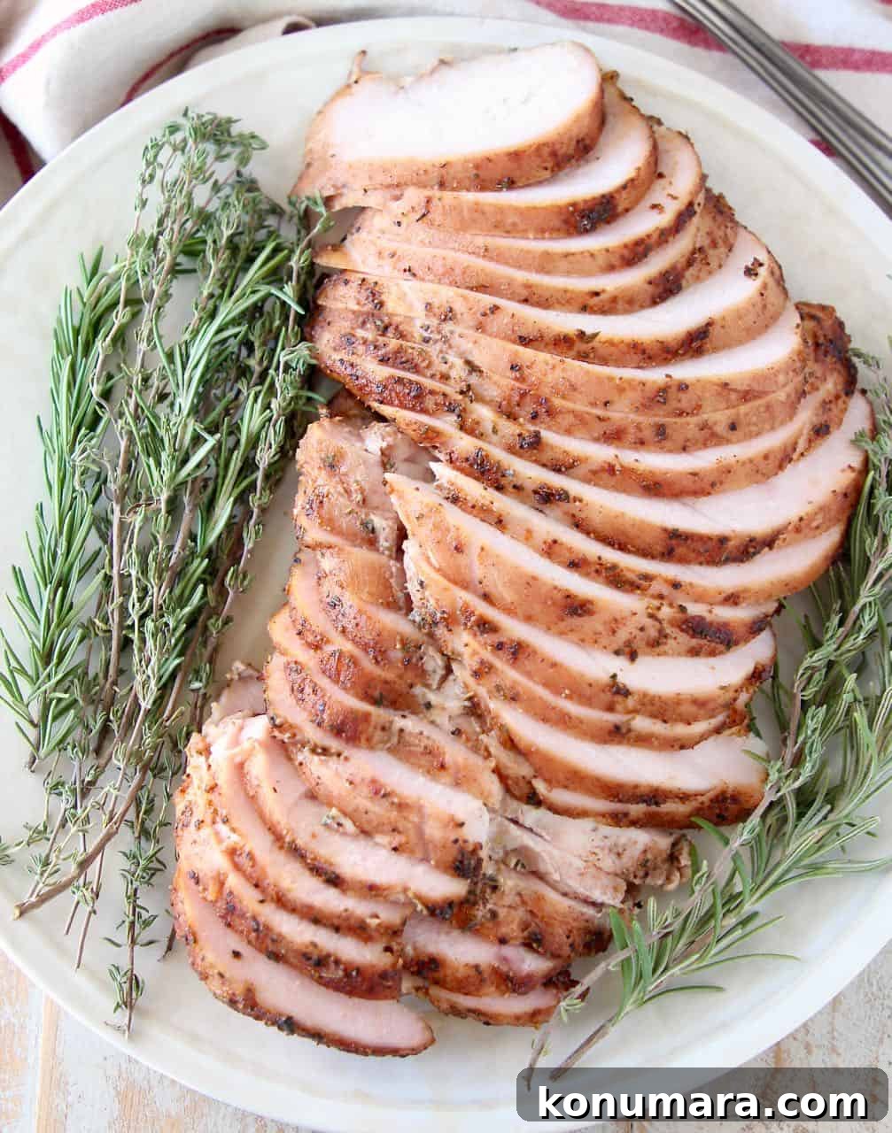 Slices of smoked turkey breast meat on plate with fresh herbs
