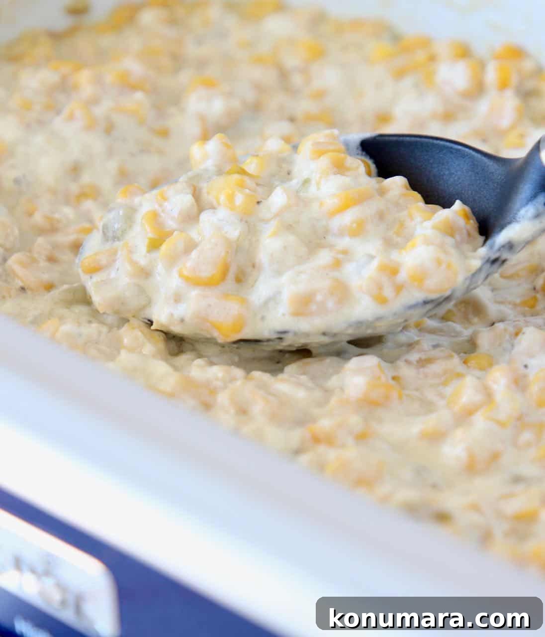 Creamed corn in crock pot with serving spoon