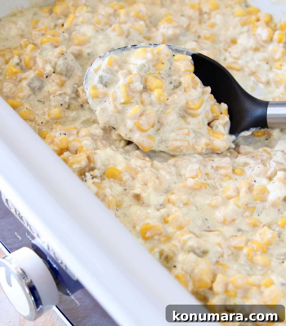 Creamed corn in slow cooker with serving spoon