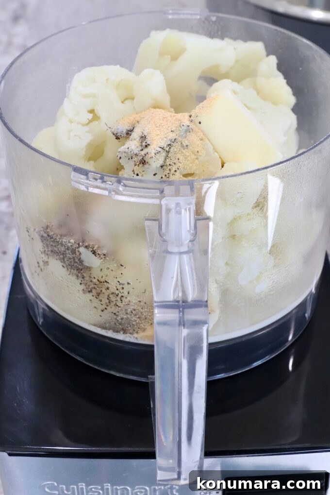 steamed cauliflower in a food processor with spices and butter