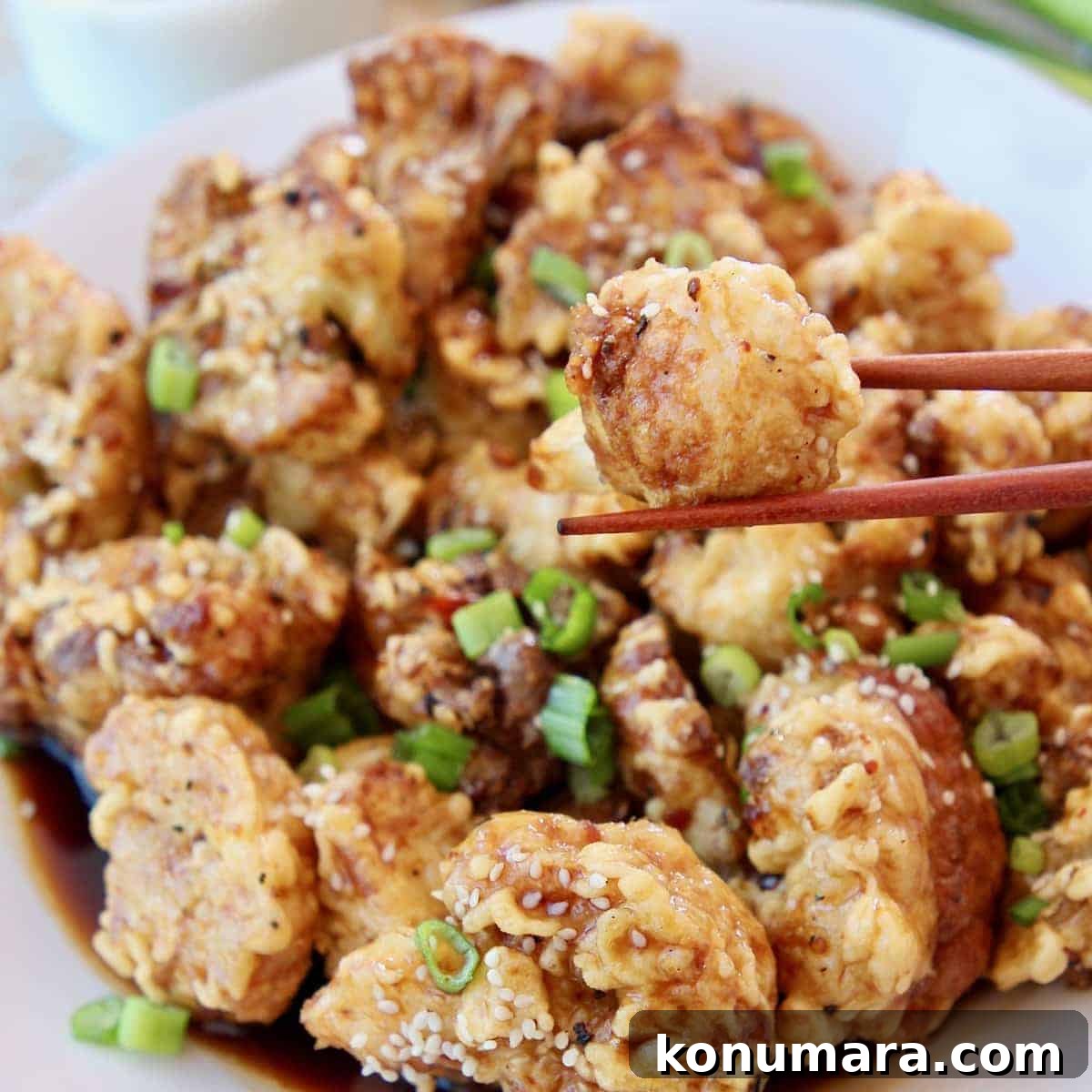 19 New Recipes from 2019 Worth Revisiting 19 Piece of fried cauliflower in chopsticks, held over plate of fried cauliflower with Korean BBQ sauce