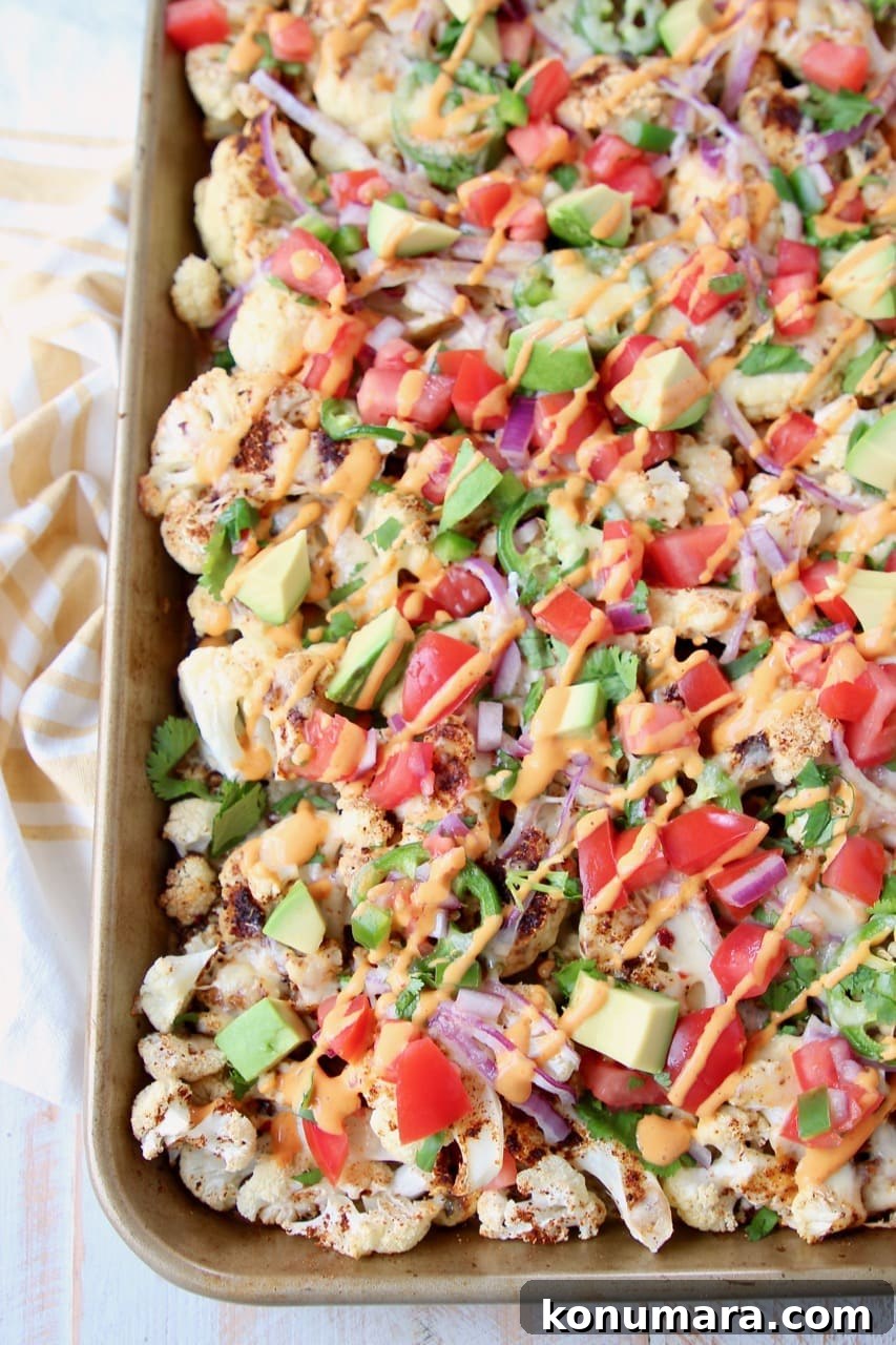 19 New Recipes from 2019 Worth Revisiting 9 Overhead shot of cauliflower nachos on a baking sheet with chipotle cream sauce drizzled on top