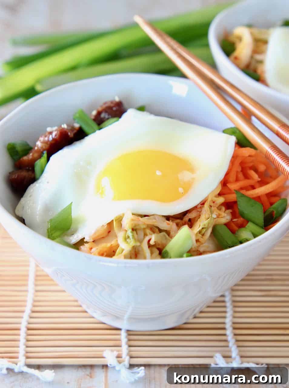Korean BBQ Cauliflower Rice Bowl with Gochujang Glaze 4 Korean BBQ Cauliflower Rice Bowl topped with a fried egg and chopsticks