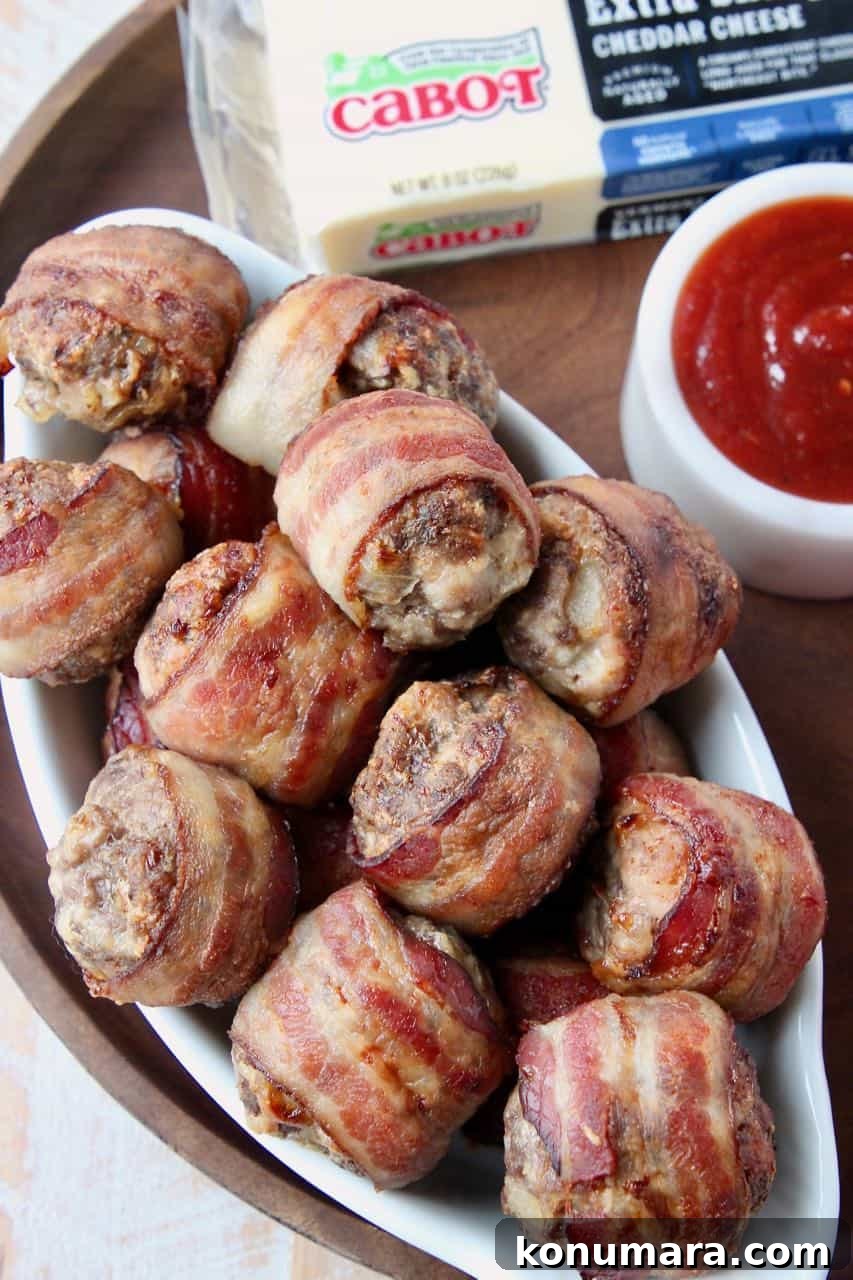Bacon wrapped meatballs in white serving dish on wood serving tray