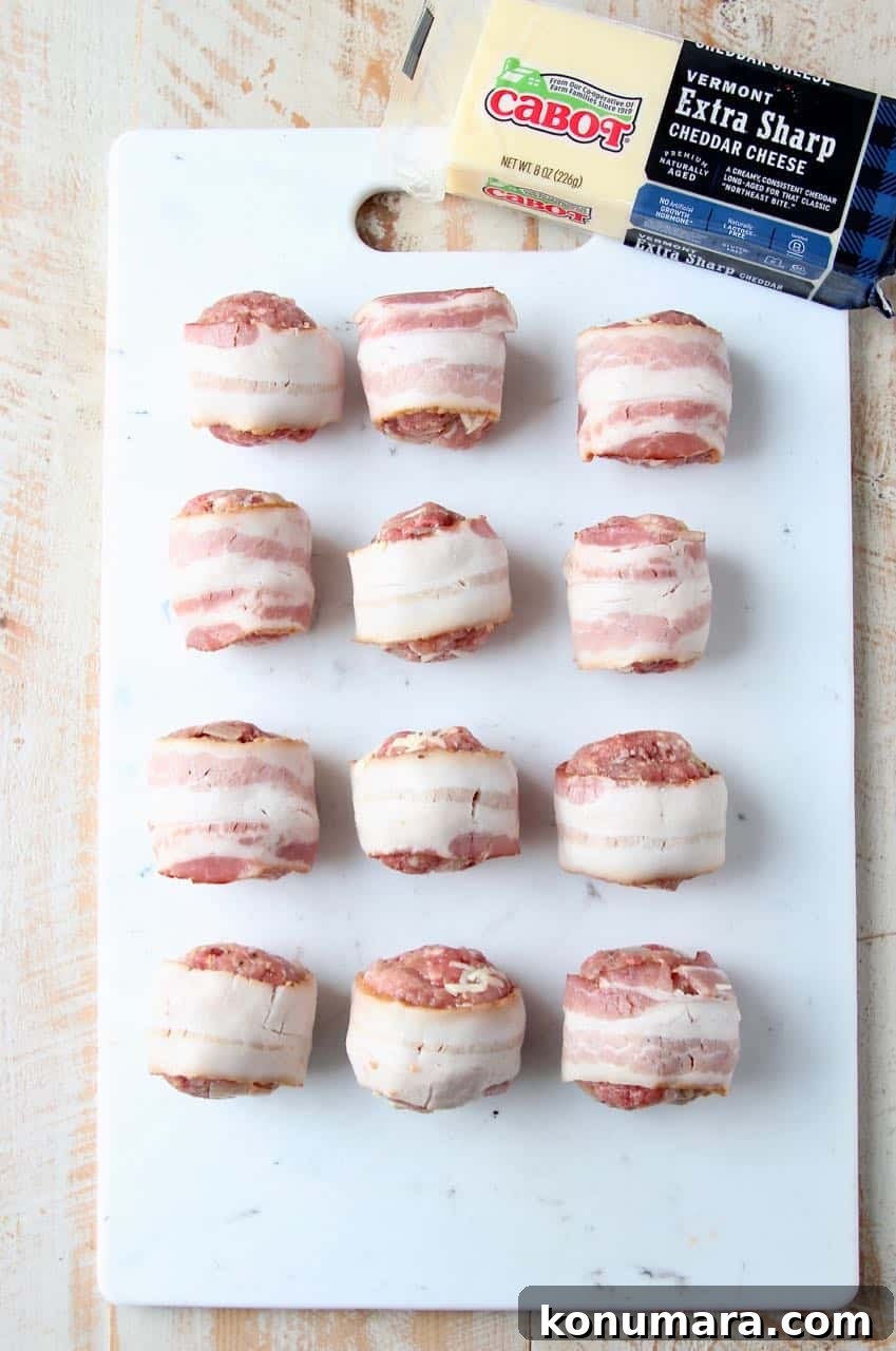Raw bacon wrapped meatballs on white cutting board