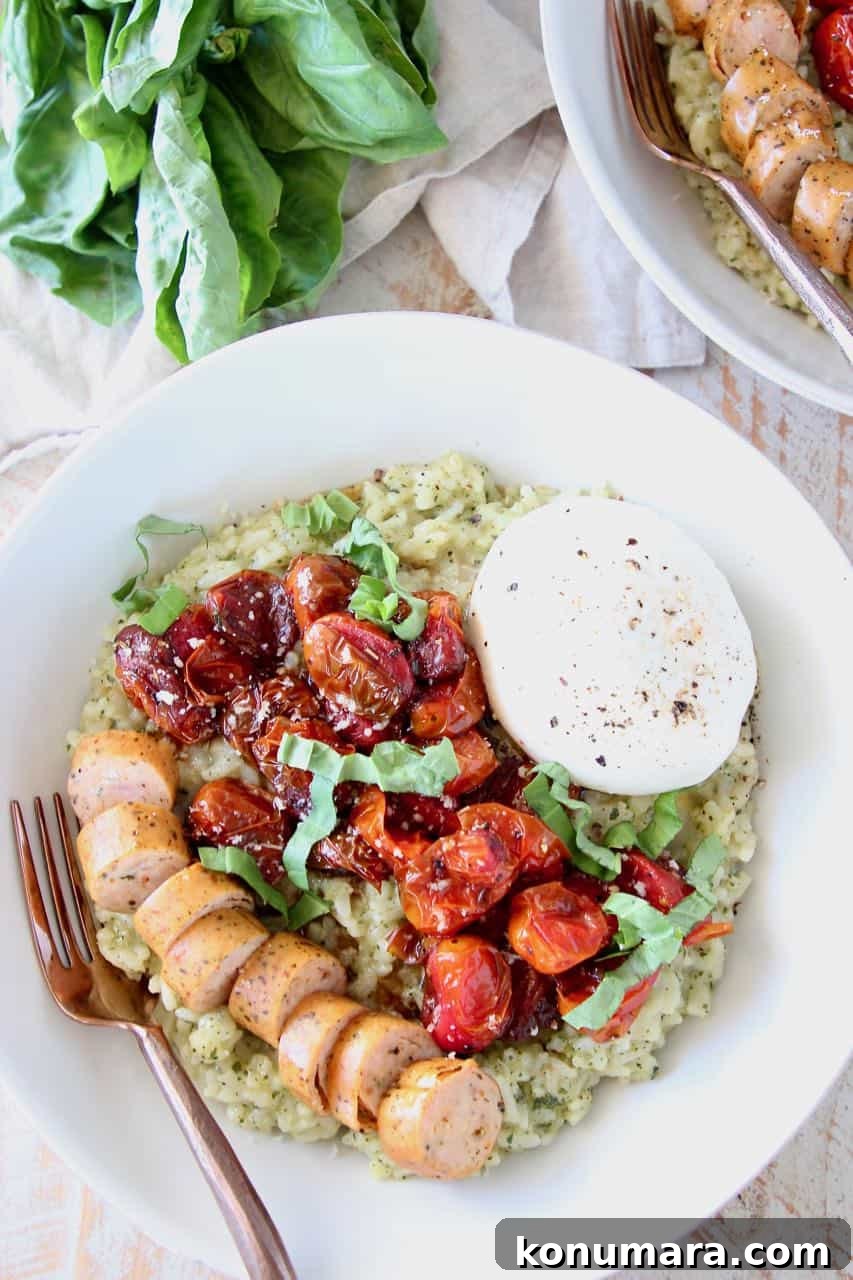 Creamy Instant Pot Pesto Risotto 2 Pesto risotto in bowl, topped with sliced sausage, roasted cherry tomatoes and burrata cheese