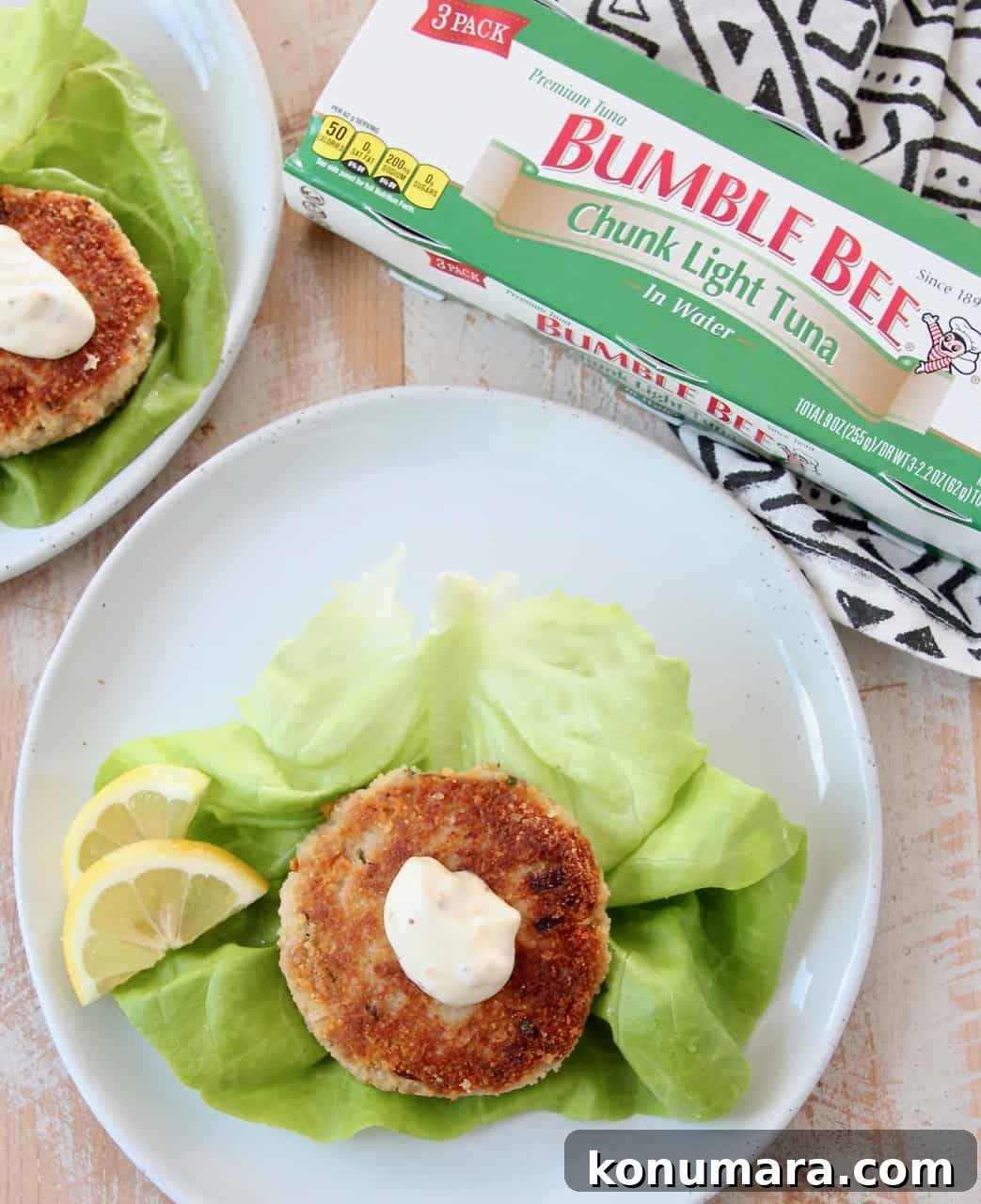 Overhead image of tuna cake topped with aioli on lettuce leaf