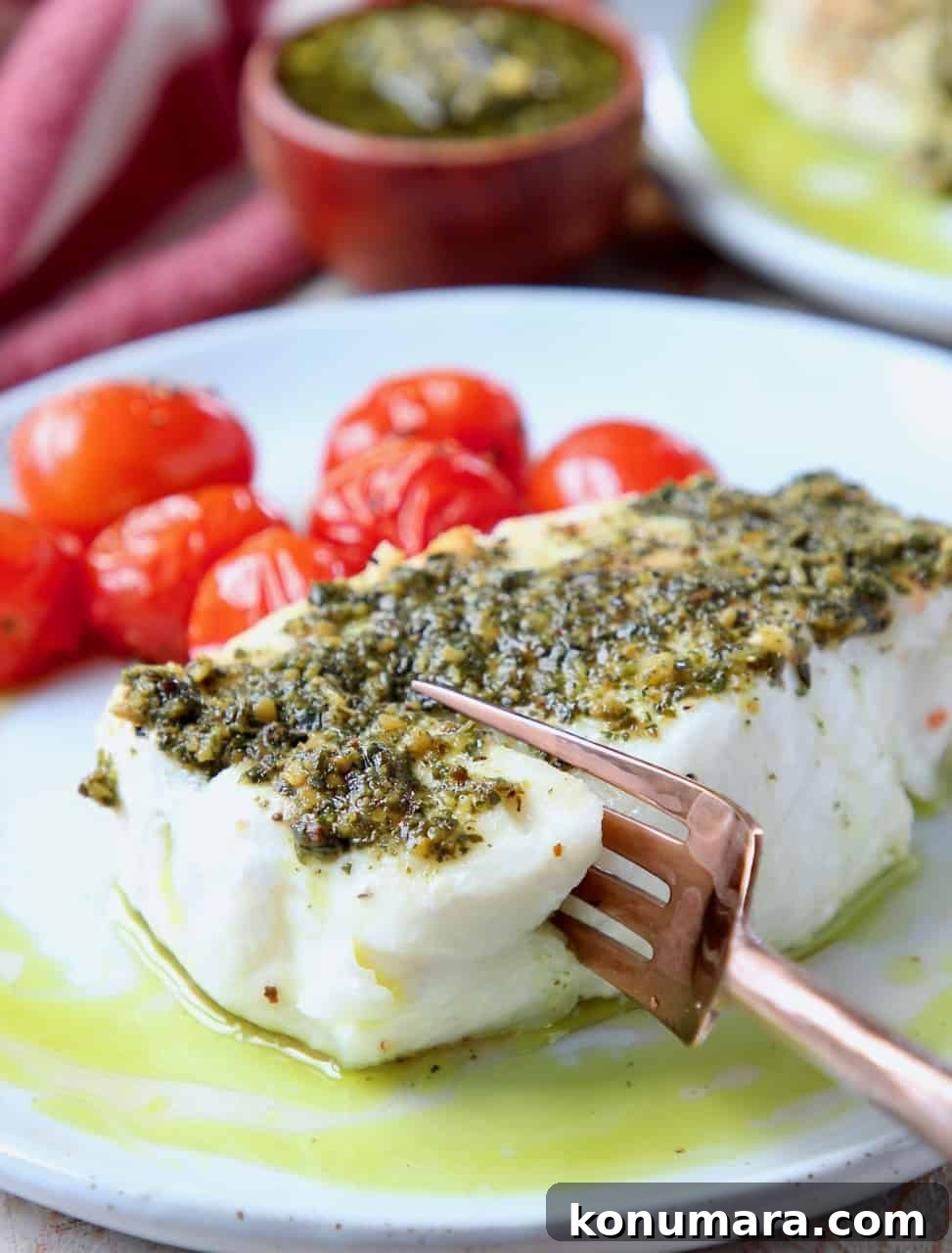 Baked Chilean Sea Bass with Basil Pesto Recipe 2 Fork cutting into sea bass on plate, topped with pesto