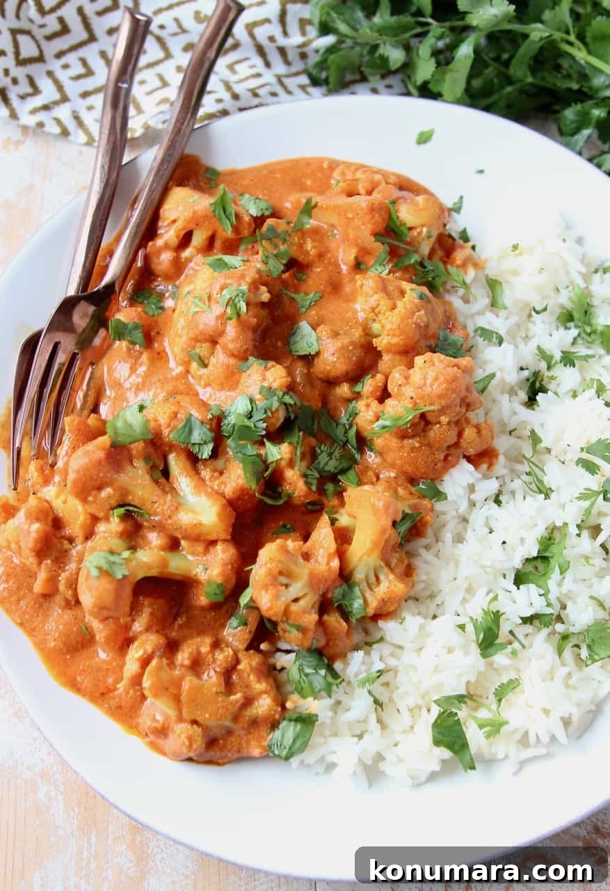 Creamy Indian Butter Cauliflower Curry Recipe 5 Cauliflower covered in curry sauce on plate with rice and forks