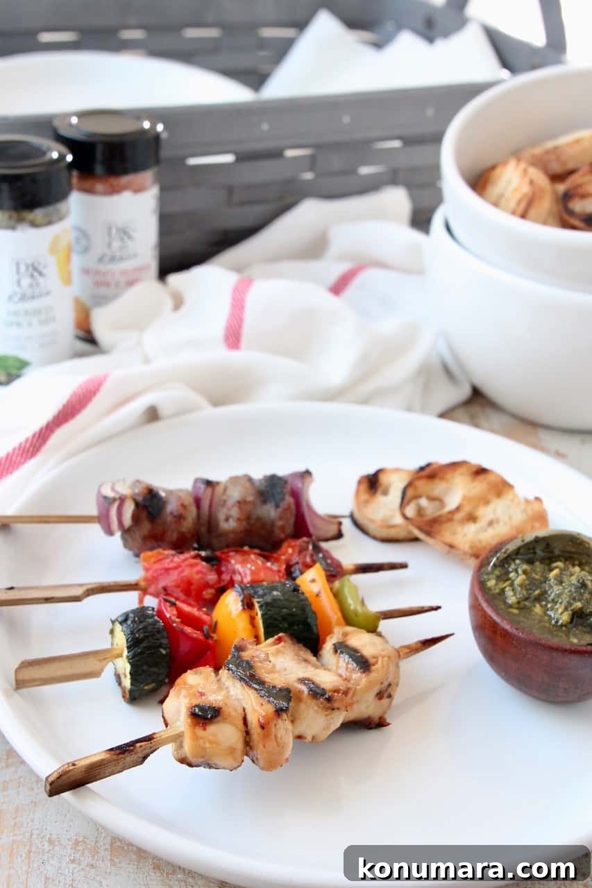 Grilled Charcuterie Board with Mini Skewers for Parties 6 Grilled skewers on plate with small bowl of pesto and grilled slices of bread