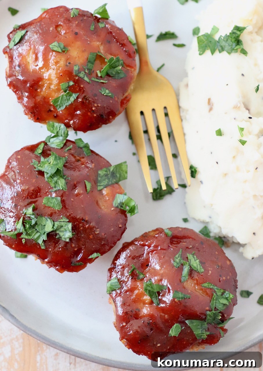 Maple-Glazed Mini Meatloaves Recipe 11 mini bbq glazed meatloaves on plate with fork and mashed potatoes