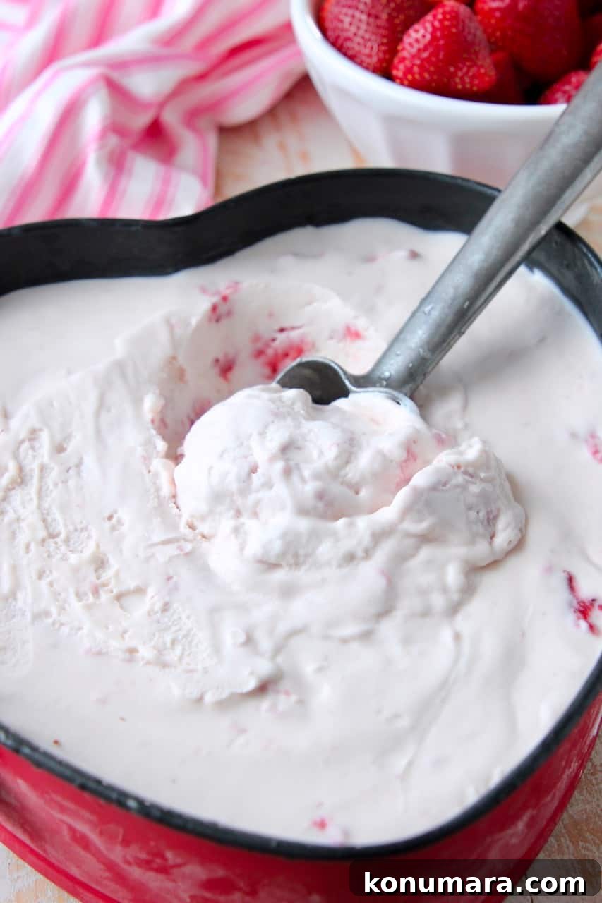 Creamy No-Churn Strawberry Ice Cream Recipe 5 Strawberry ice cream being scooped out of metal pan