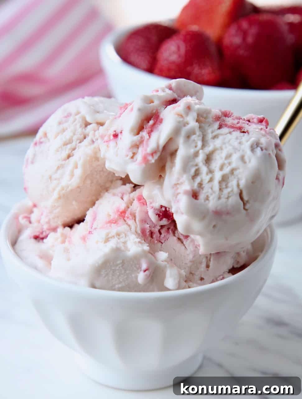 Creamy No-Churn Strawberry Ice Cream Recipe 6 Scoops of strawberry ice cream in white bowl