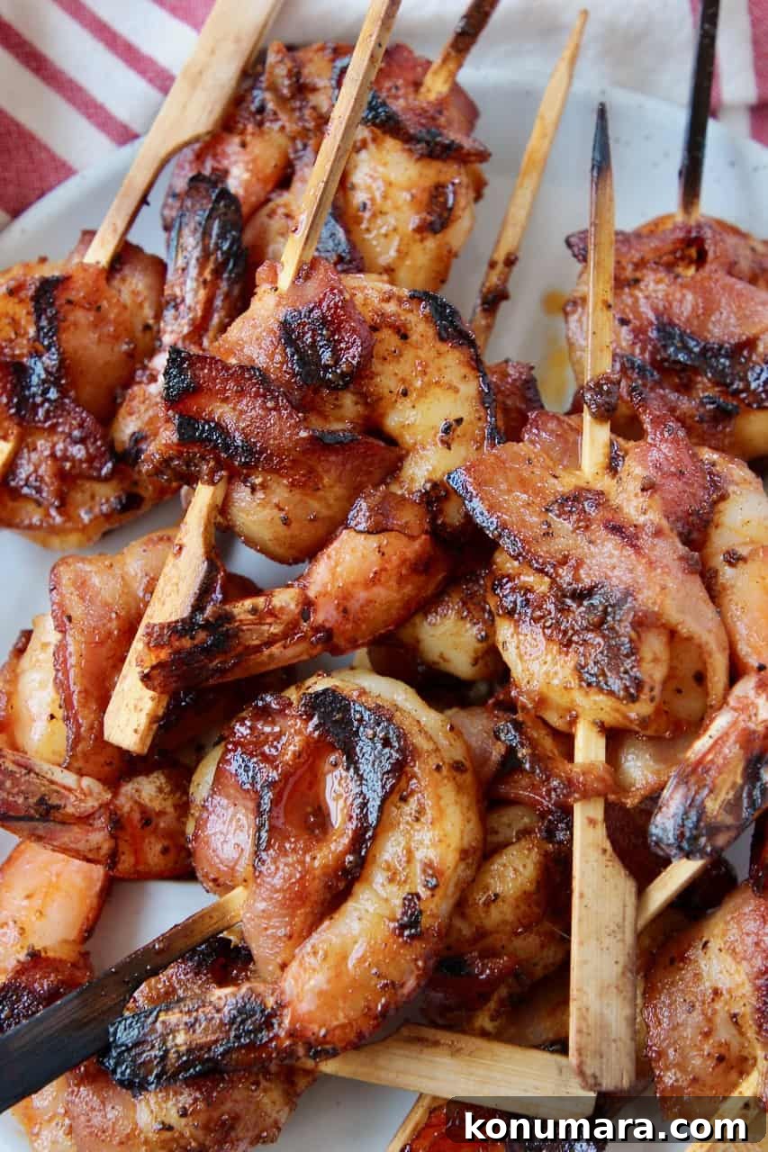 Grilled Bacon-Wrapped Shrimp Skewers 2 Bacon wrapped shrimp piled on plate