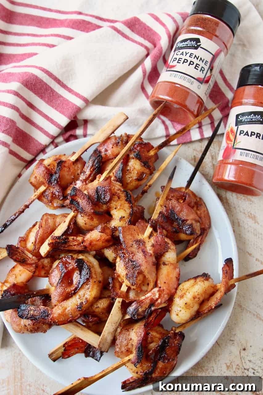 Grilled Bacon-Wrapped Shrimp Skewers 6 Skewered bacon wrapped shrimp on plate