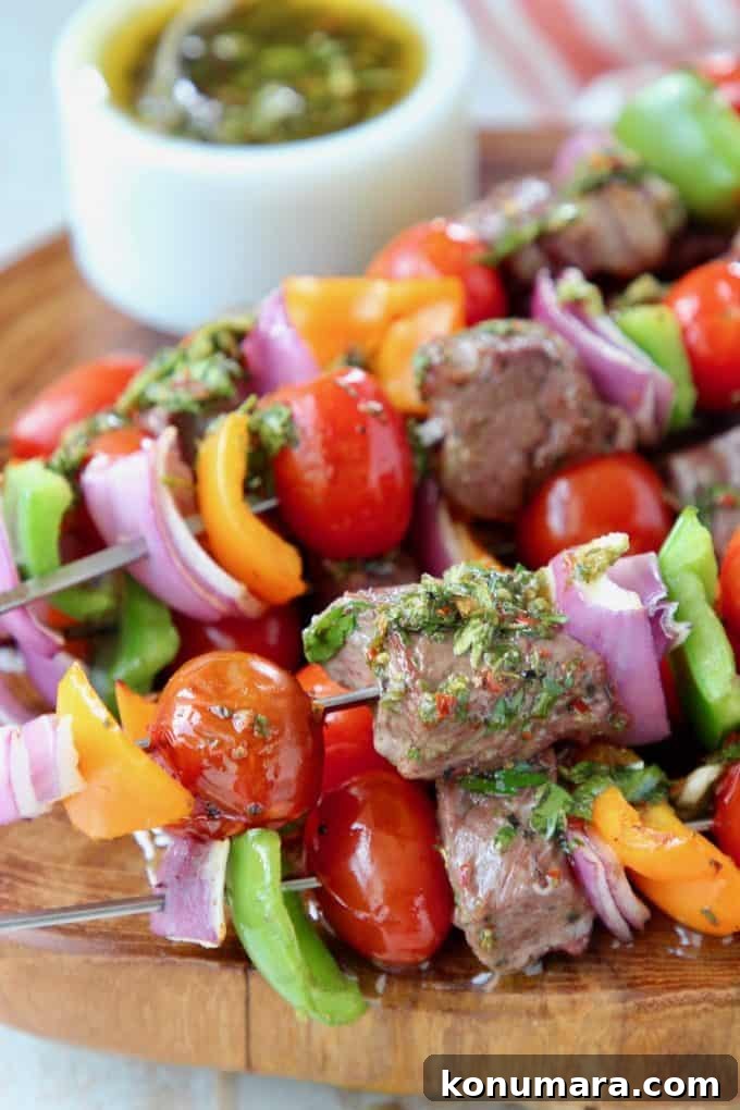 Grilled Ribeye Steak Kabobs with Chimichurri Sauce Recipe 3 Steak kabobs with veggies on wood board