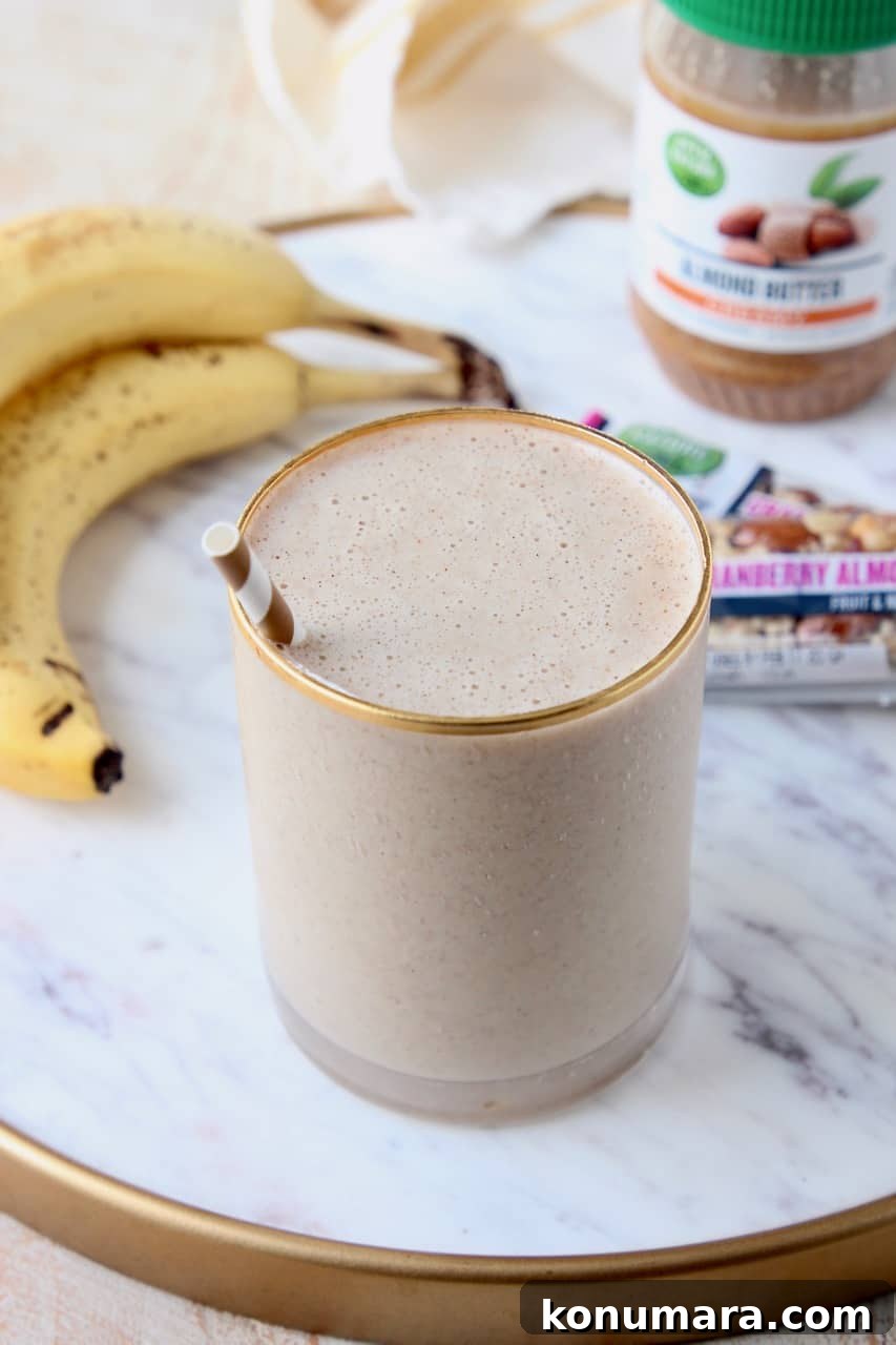 Almond Milk Smoothie Recipe with Banana and Protein 5 smoothie in glass with straw, sitting next to bananas