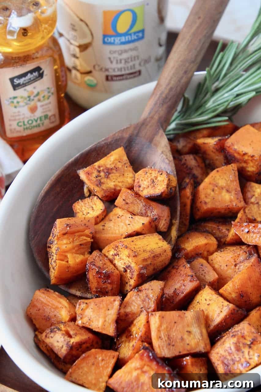 honey roasted cubed sweet potatoes in bowl with wooden serving spoon