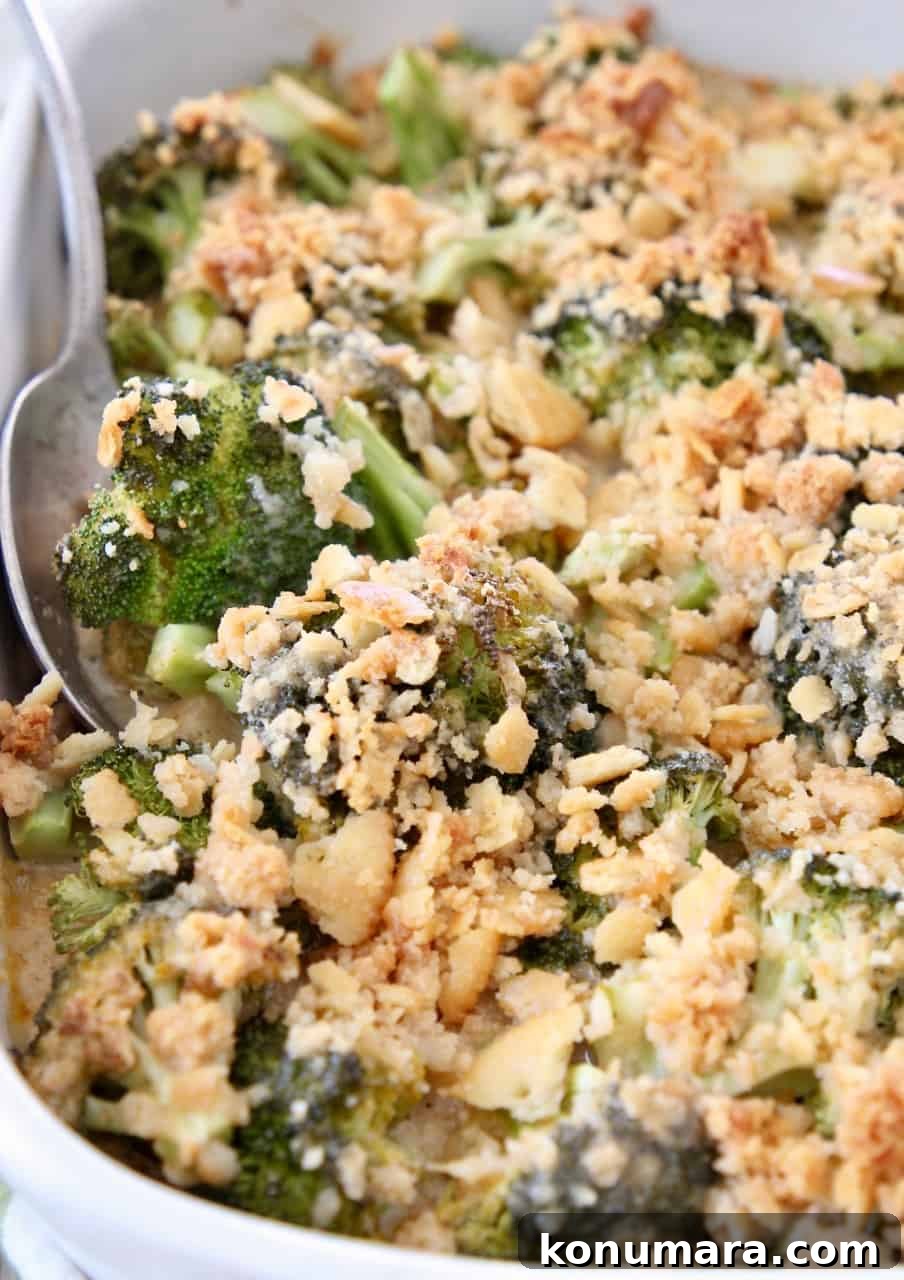 broccoli casserole topped with ritz crackers with serving spoon in the dish