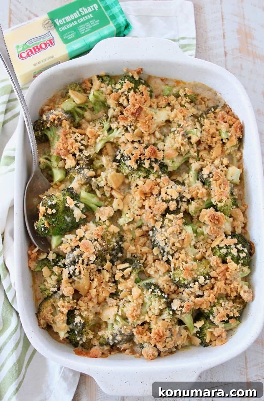 overhead image of broccoli casserole with ritz topping in casserole dish with serving spoon
