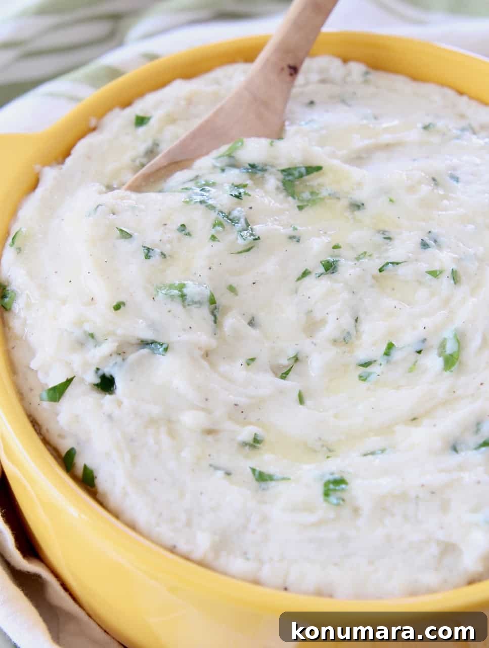 Creamy Instant Pot Mashed Potatoes Recipe 5 mashed potatoes in yellow bowl with wooden spoon