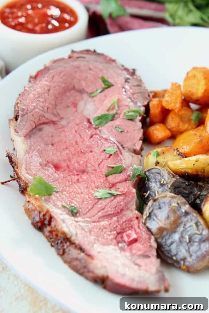 Slice of prime rib on plate with roasted vegetables