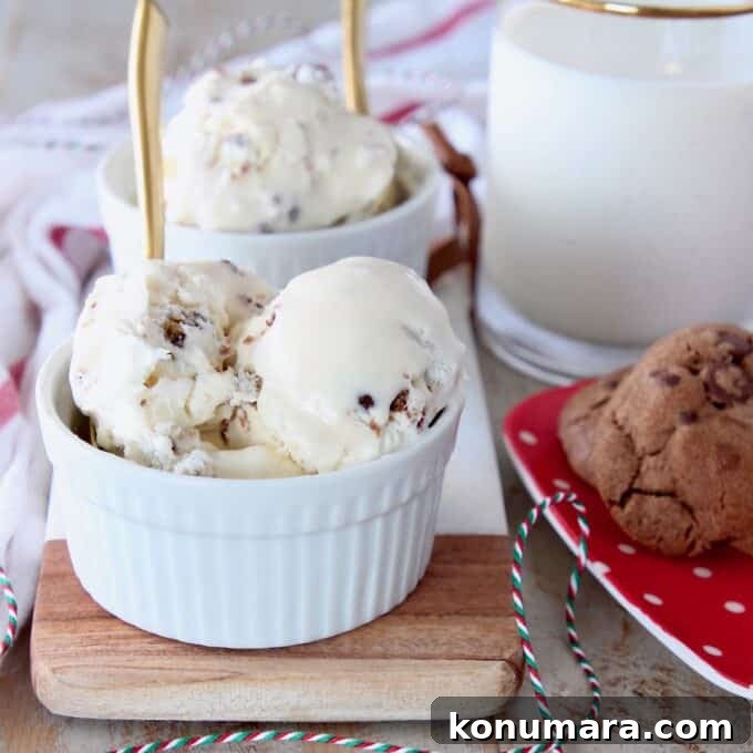 scoops of ice cream in white bowls with gold spoons, with a plate of cookies on the side