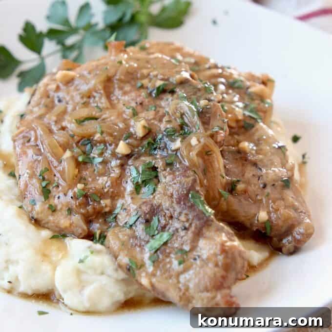 20 Must-Try Recipes from 2020 7 two pork chops on plate covered with gravy, on top of mashed potatoes