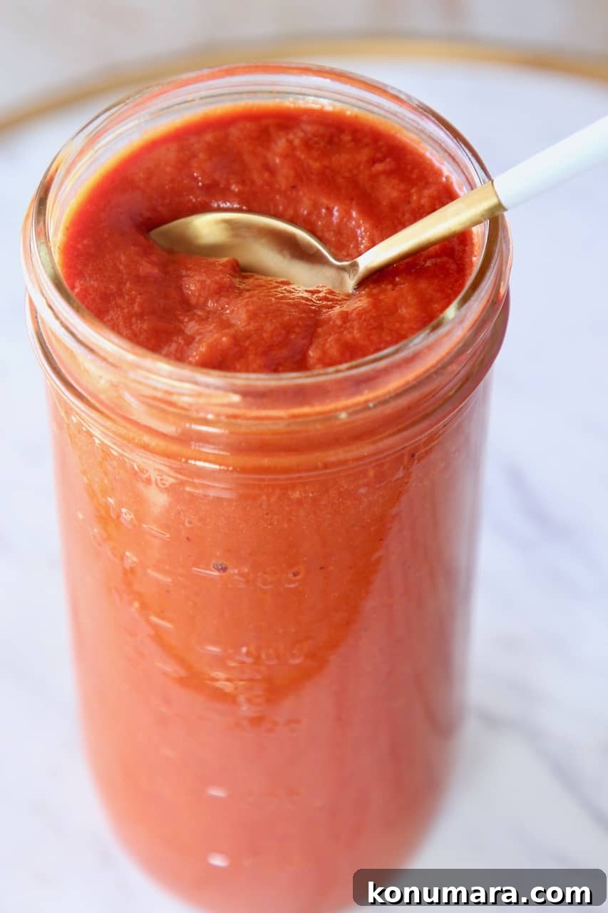spoon in mason jar of enchilada sauce